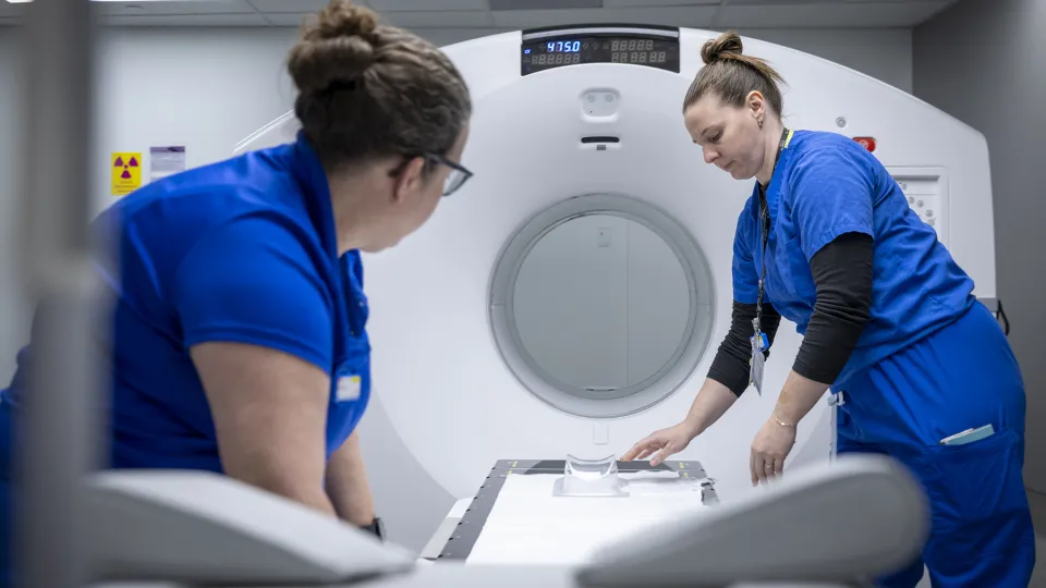 Image of KHSC staff setting up the PET-CT scanner for patient use.