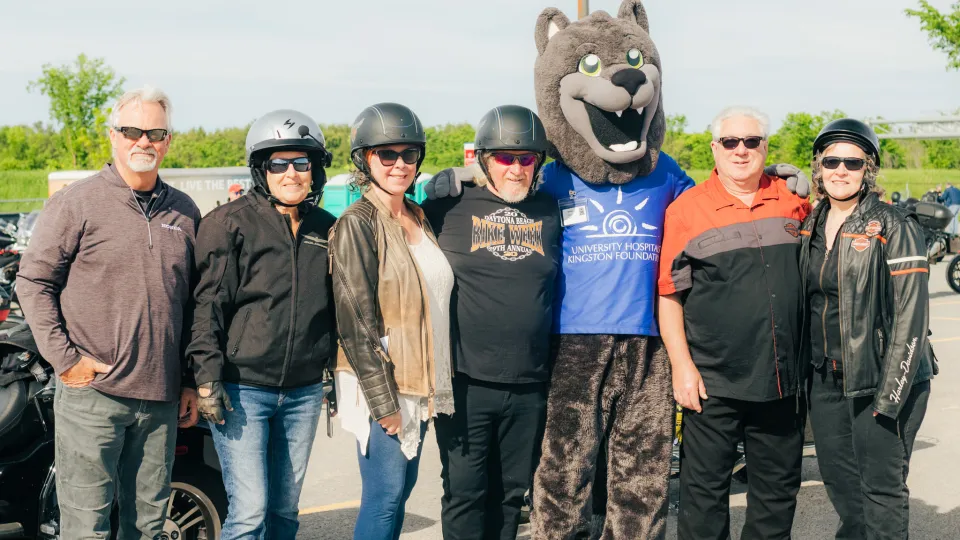 Bikers with their arms around UHKF's Asher.