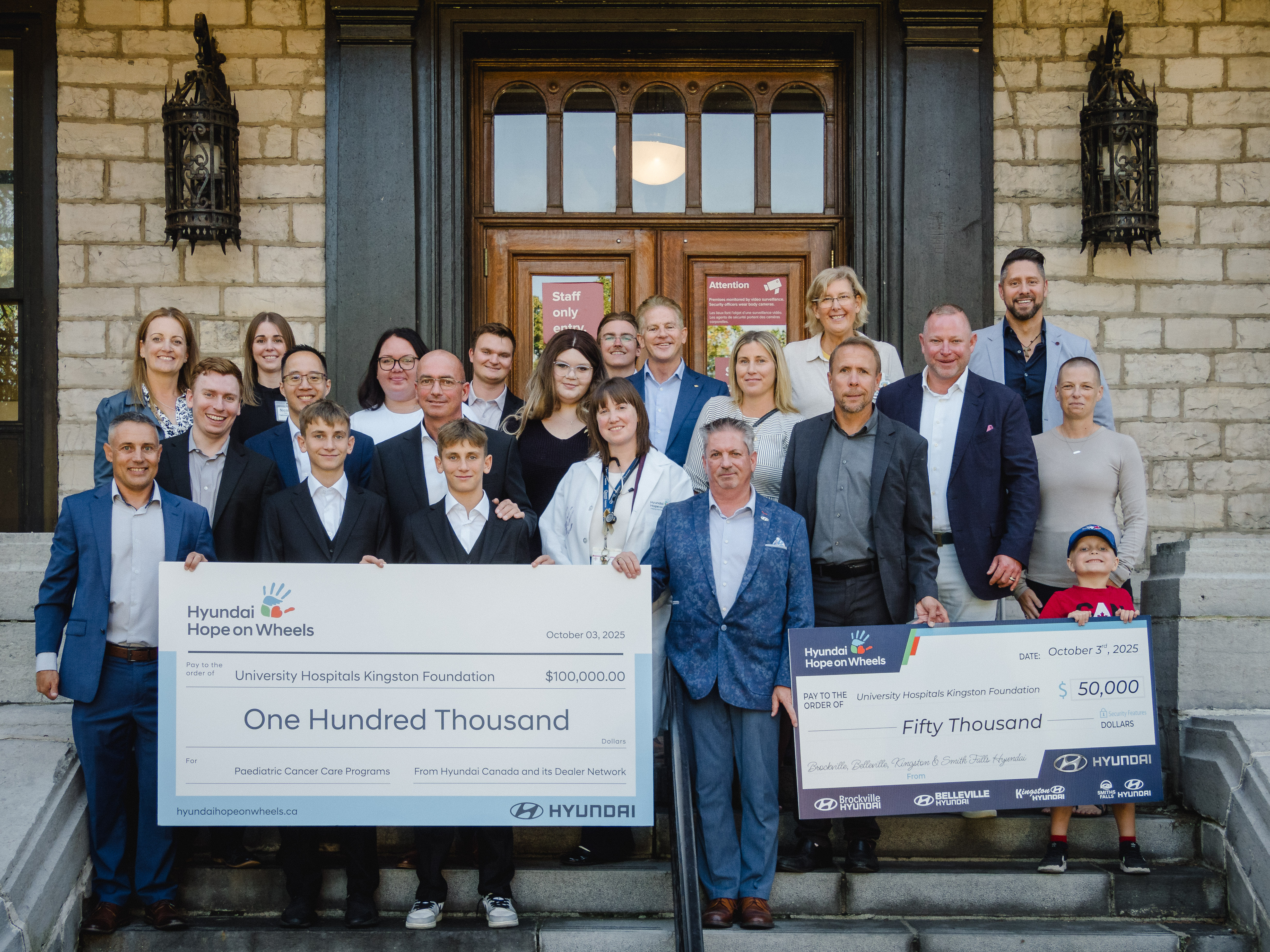Group shot of Hyundai Hope on Wheels, Hyundai Canada, Kingston Health Sciences Centre and University Hospitals Kingston Foundation leaders presenting the $100,000 and $50,000 cheque. 
