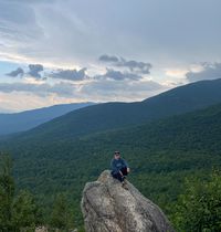 Megan sitting on a cliff edge.