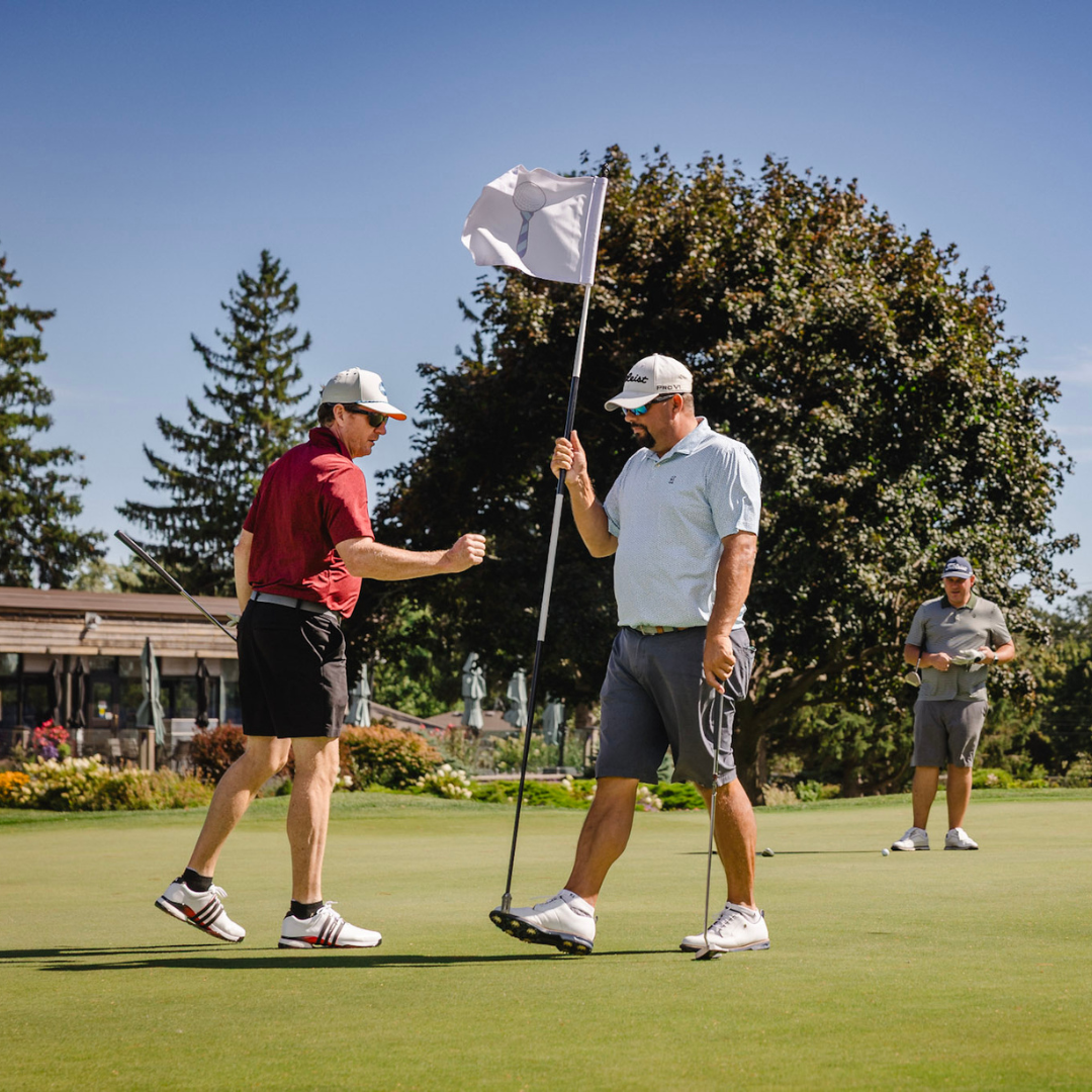 Golfers moving Power of Hope flag.