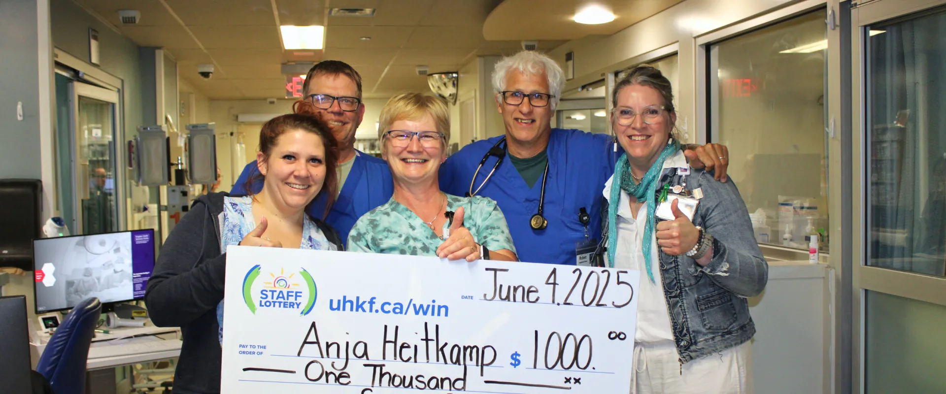Anja Heitkamp and team holding her $1000 staff lottery cheque.