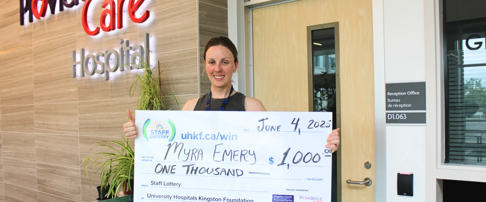 Myra Emery holding her $1000 staff lottery cheque in the Providence Care lobby.