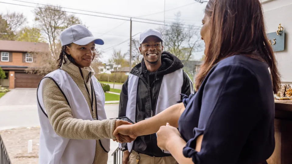 Canvassers talking to a person on their doorstep.