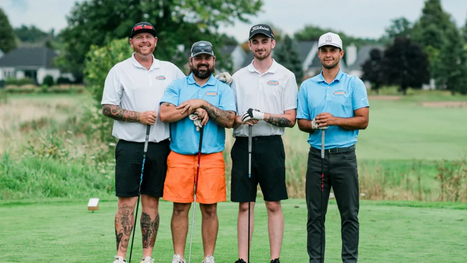Mascon Restorations staff wearing blue and orange golf shirts and shorts at their 2nd annual golf tournament.