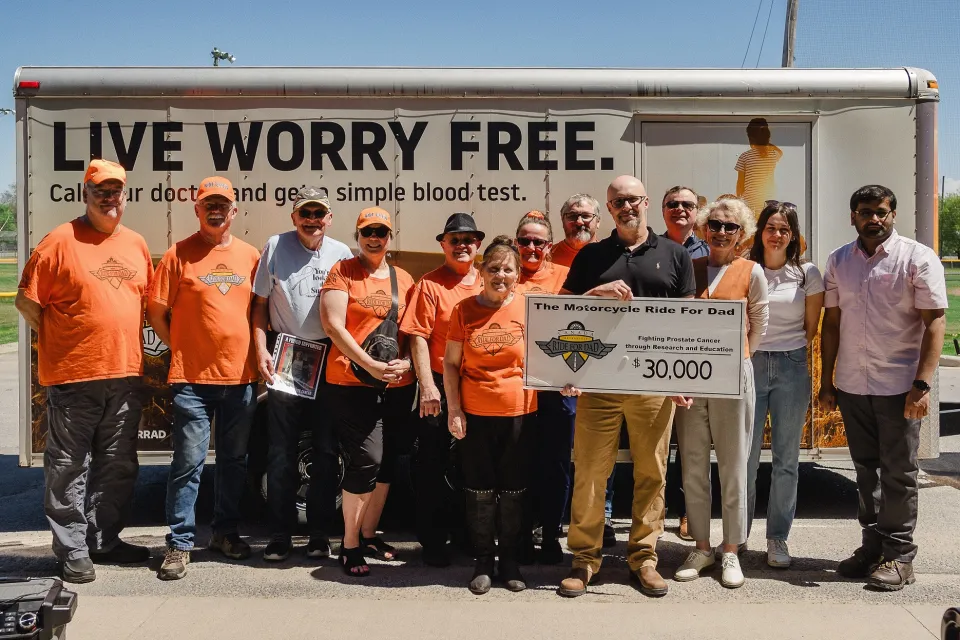 Ride for Dad organizers present a $30,000 cheque to Dr. John Allingham