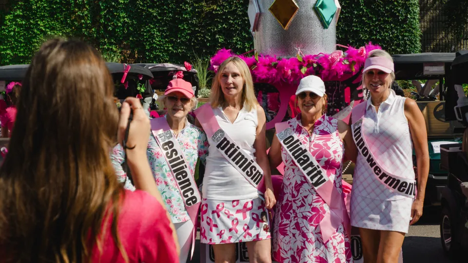 Women wearing pink golfing outfits.