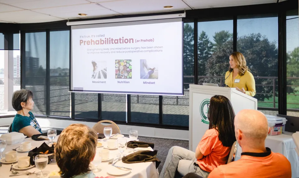 Dr. Jordan Leitch (at the podium) gives a presentation during a Women’s Giving Circle luncheon.