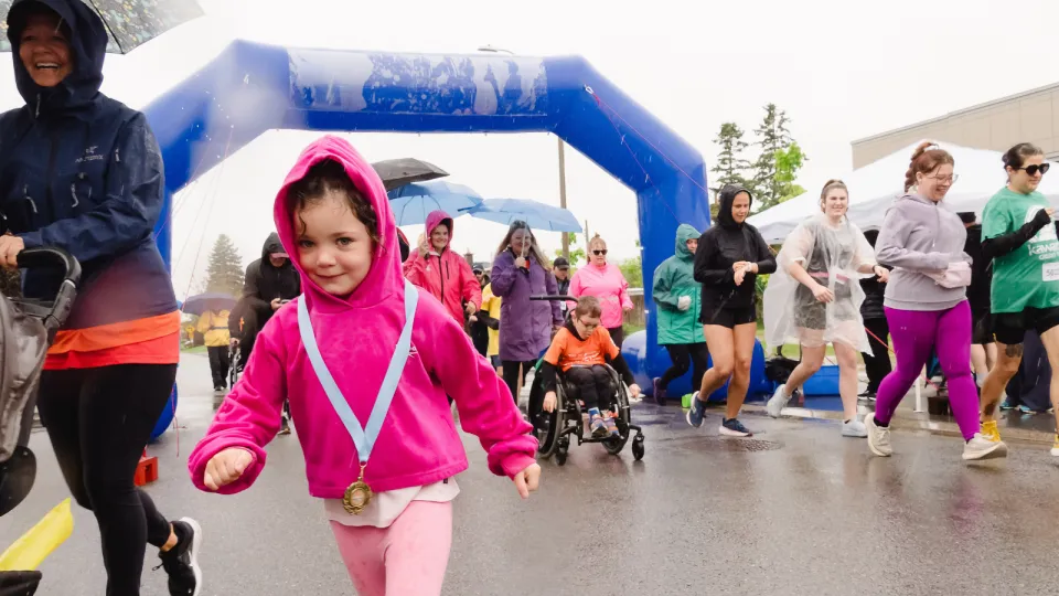 Girl running in rain at Kilometres for Kids