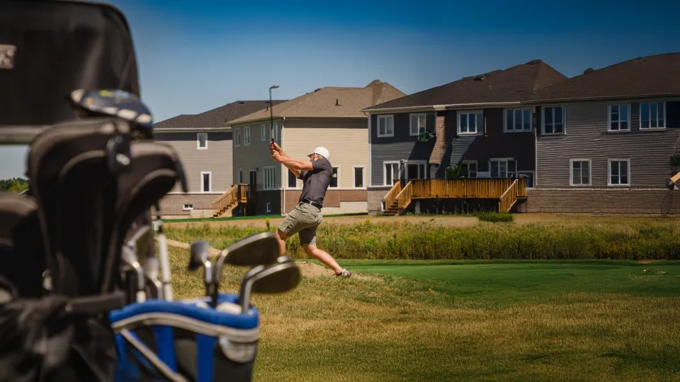 Man swinging golf club in the distance.