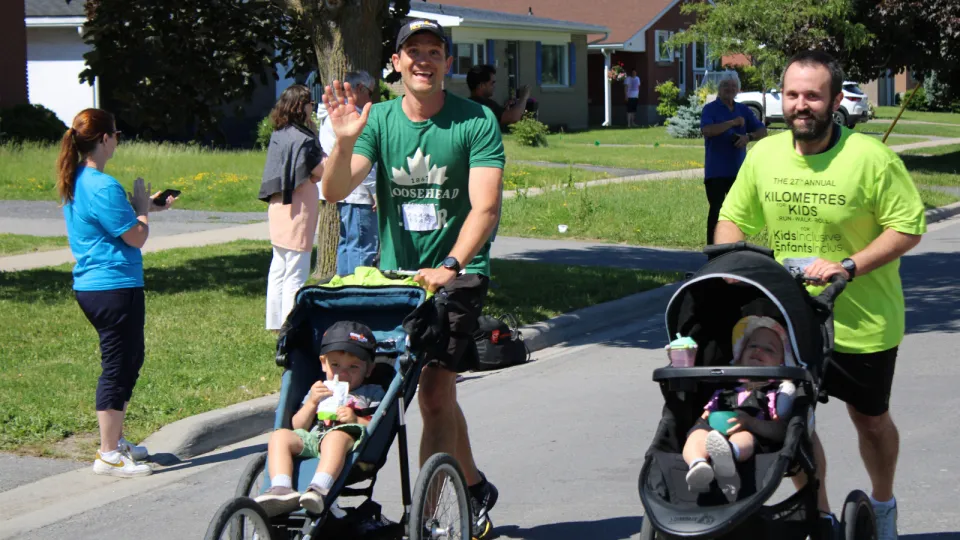 Men running while pushing baby strollers