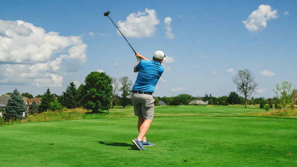 YGK Healthcare Champion swinging golf club on course.