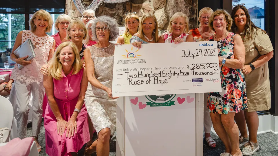 The Rose of Hope Golf Tournament organizers holding a big donation cheque while smiling.