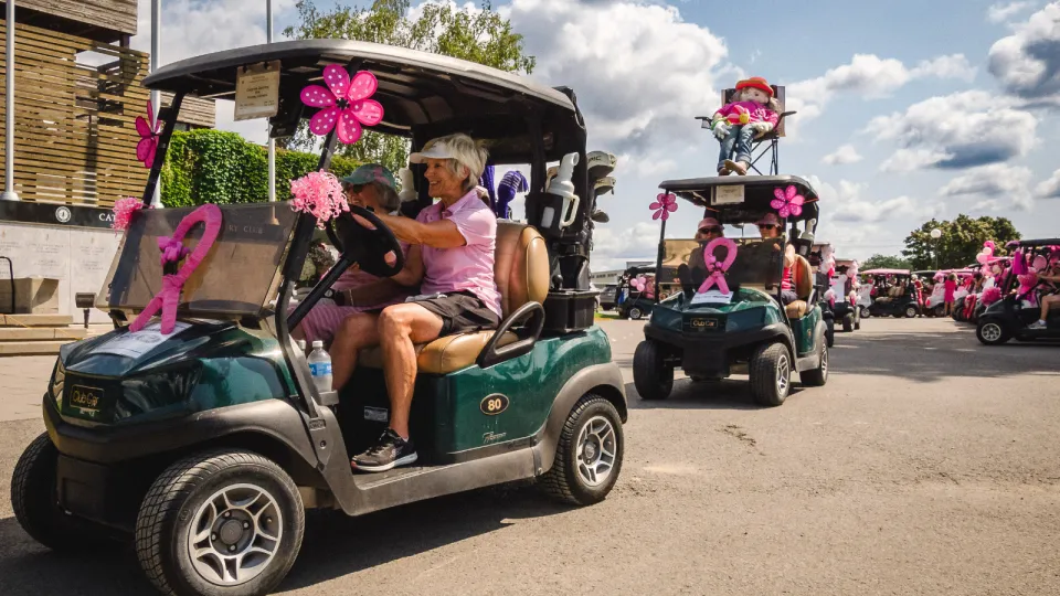 Golfers driving decorated golf carts at the Rose of Hope Golf Tournament.