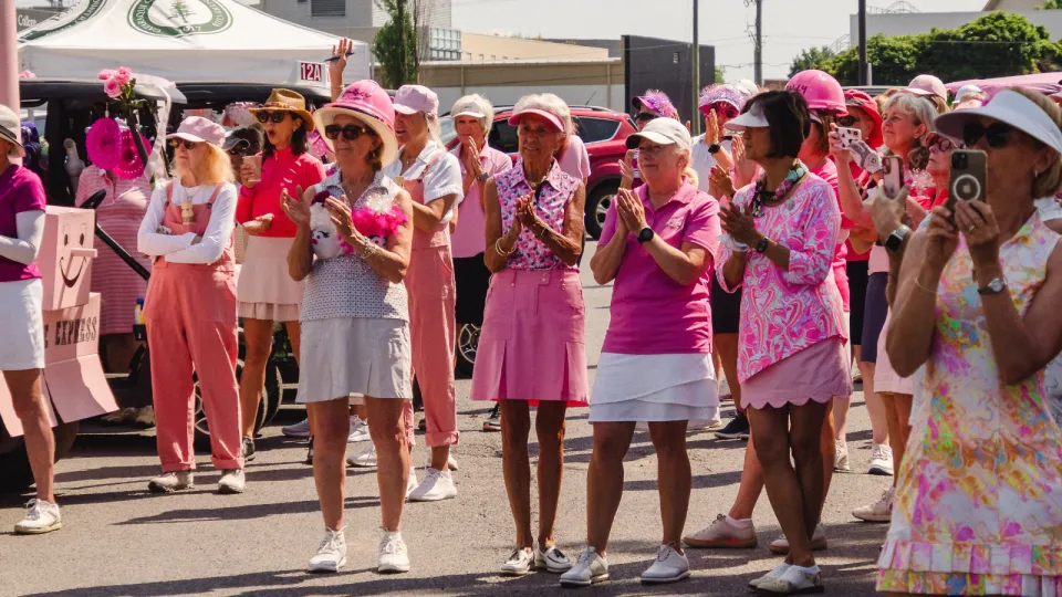 Golfers all wearing pink in a group at the Rose of Hope Golf Tournament.