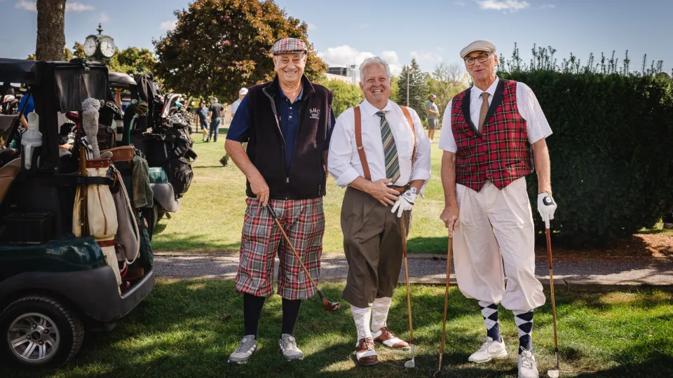 Three male golfers wearing classic tartan gear.