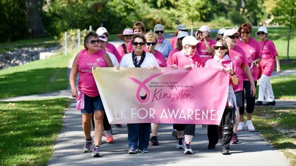 2025 Walk for Awareness. Female walkers dressed in pink holding BCAK banner.