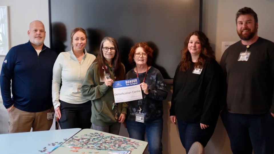 Detox Centre team smiling and holding and Honour Your Caregiver certificiate.