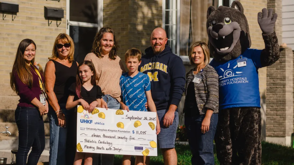 Carman family holding big cheque showing 2025 proceeds.