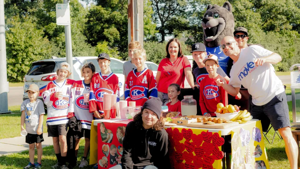 Hockey team posing with 98.3 fly fm radio hosts.