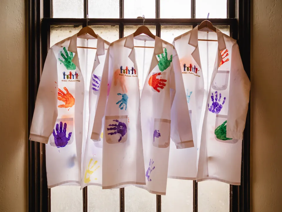 Lab coats with painted hand prints.
