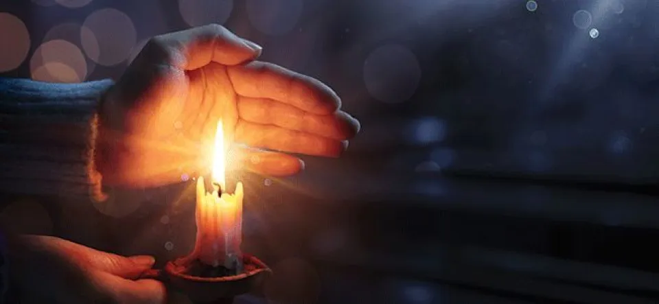 Hands around candle