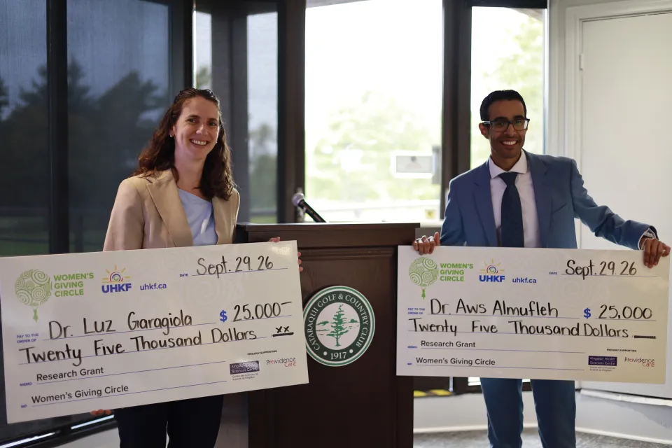 Dr. Aws Almufleh and Dr. Maria Luz Garagiola holding ceremonial cheques