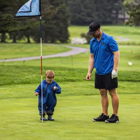 Brock Turner playing golf with his toddler son.