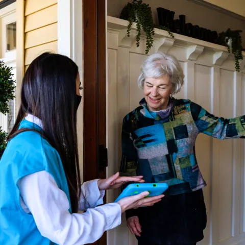 Canvasser speaking to woman at door front.