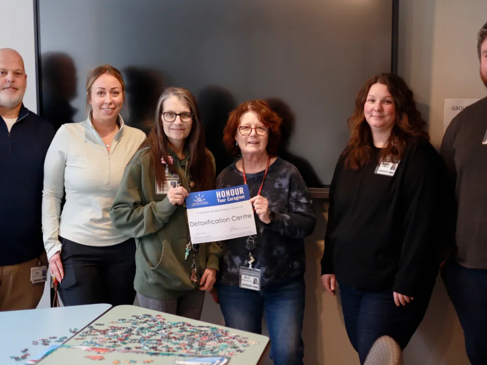 Detox Centre team smiling and holding and Honour Your Caregiver certificiate.
