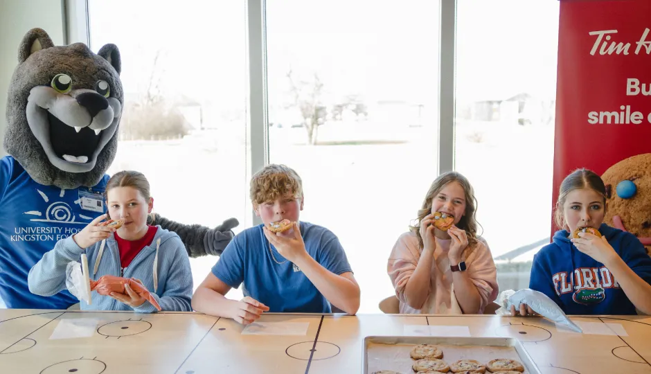 Kids eating Smile Cookies with mascot.