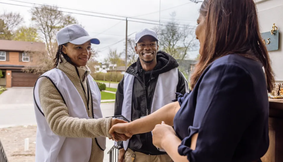 Canvassers talking to a person on their doorstep.