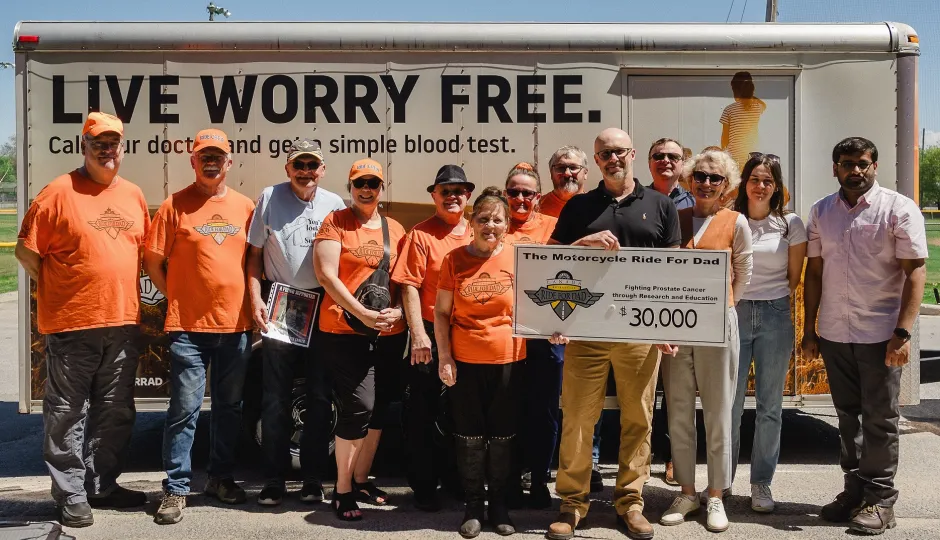 Ride for Dad organizers present a $30,000 cheque to Dr. John Allingham