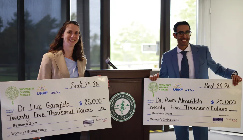 Dr. Aws Almufleh and Dr. Maria Luz Garagiola holding ceremonial cheques