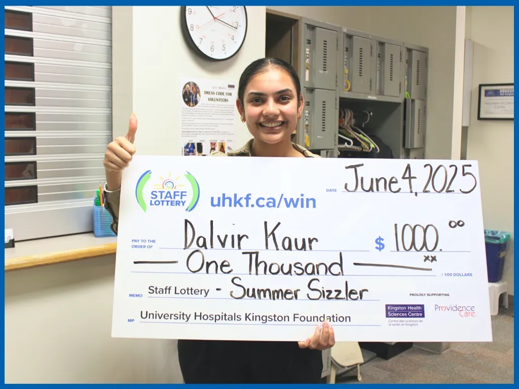 Dalvir Kaur holding large cheque.