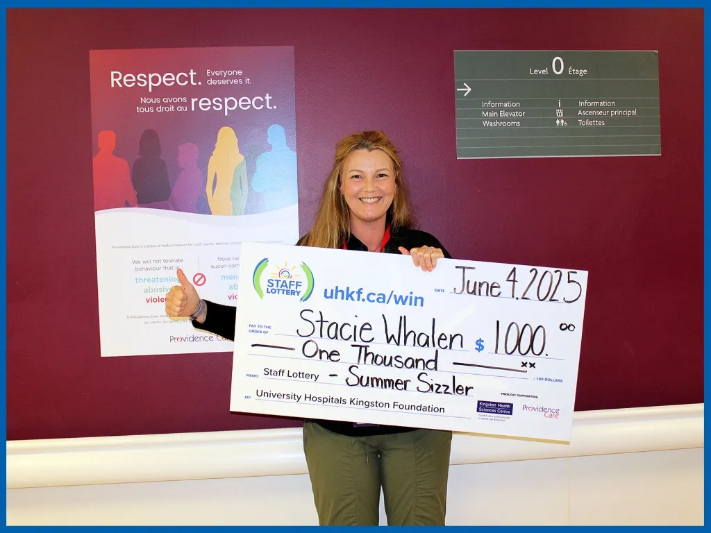 Stacie Whalen holding large cheque.