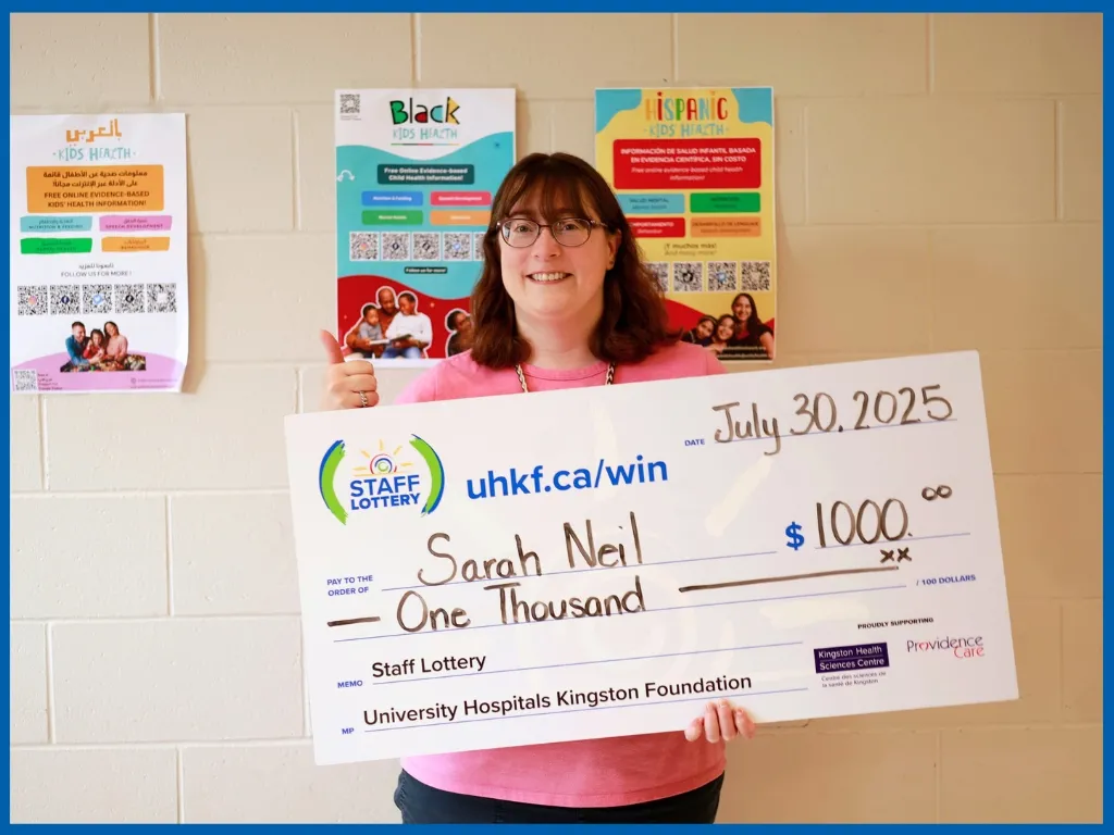 Sarah Neil holding large cheque.
