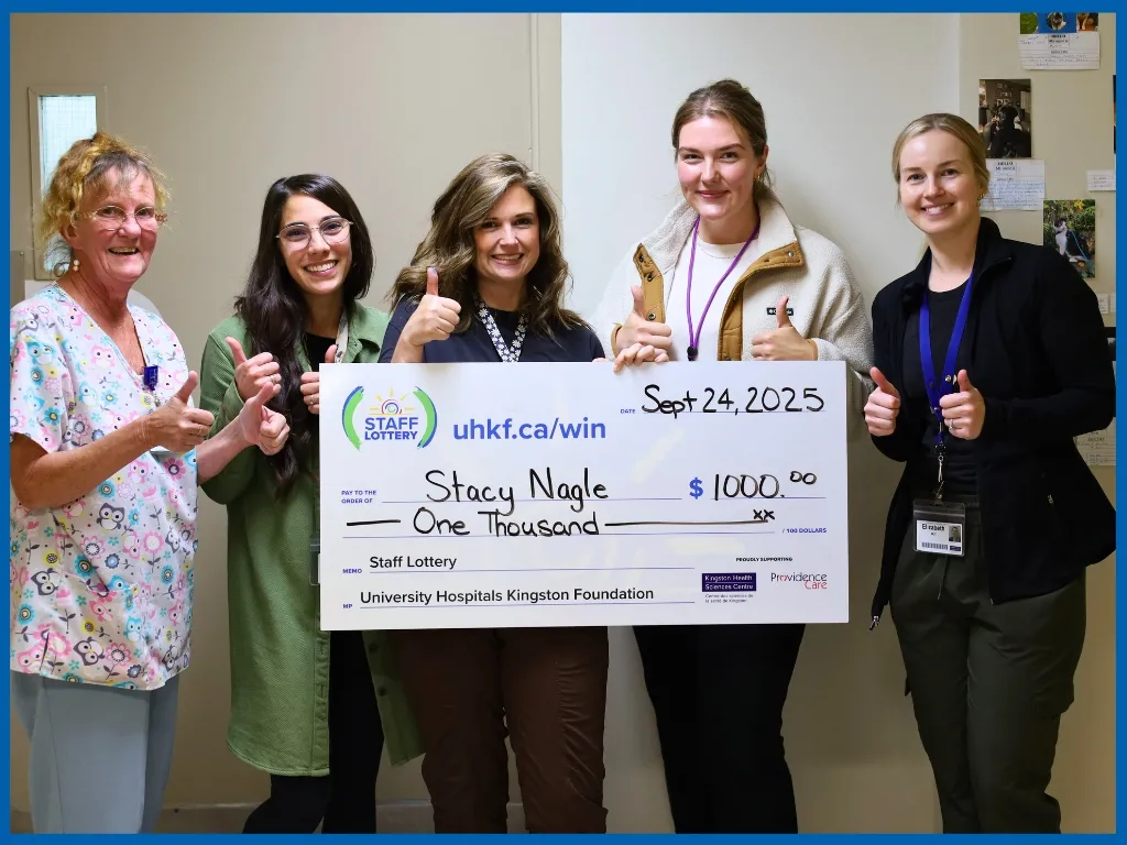 Stacy Nagle holding large cheque. 
