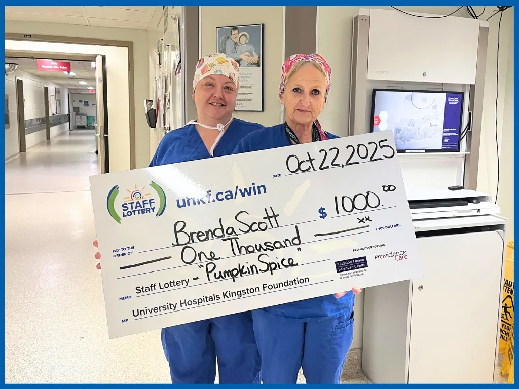 Brenda Scott holding a large cheque. 