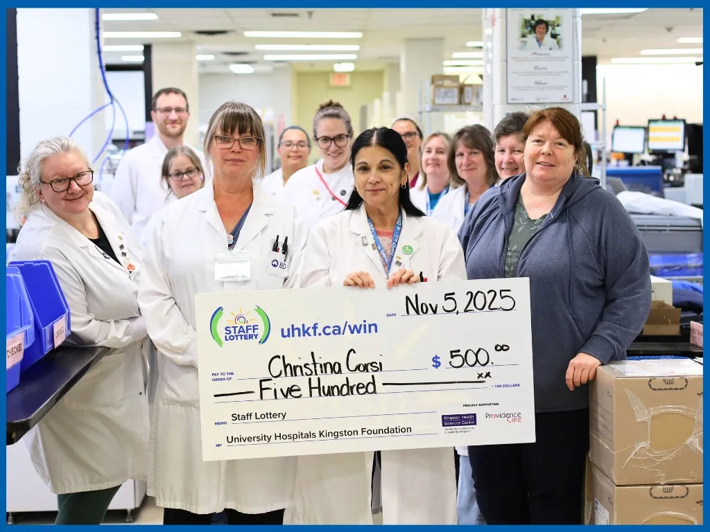 Christina Corsi holding a large cheque. 