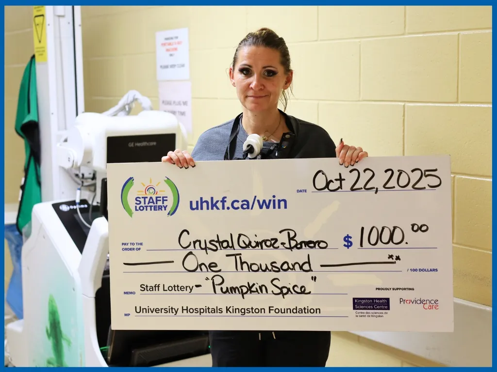 Crystal Quiroz-Borrero holding large cheque.