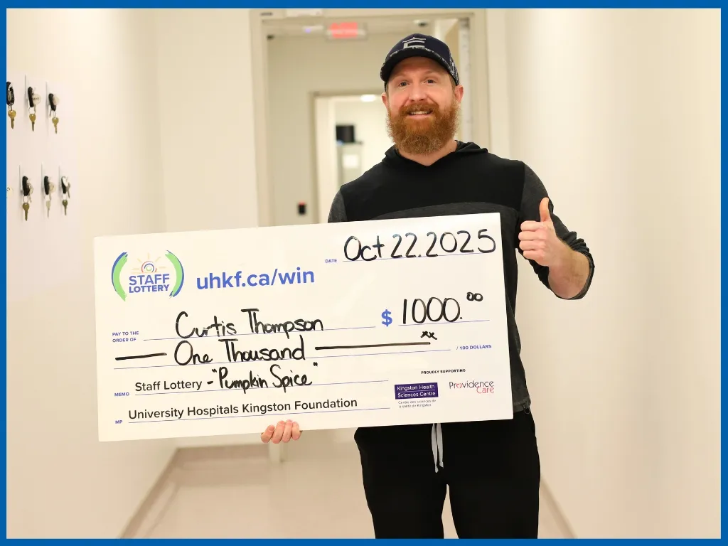 Curtis Thompson holding large cheque.