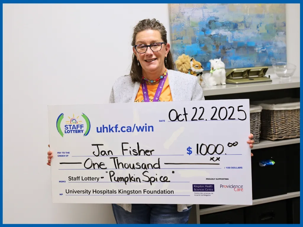 Jan Fisher holding large cheque.