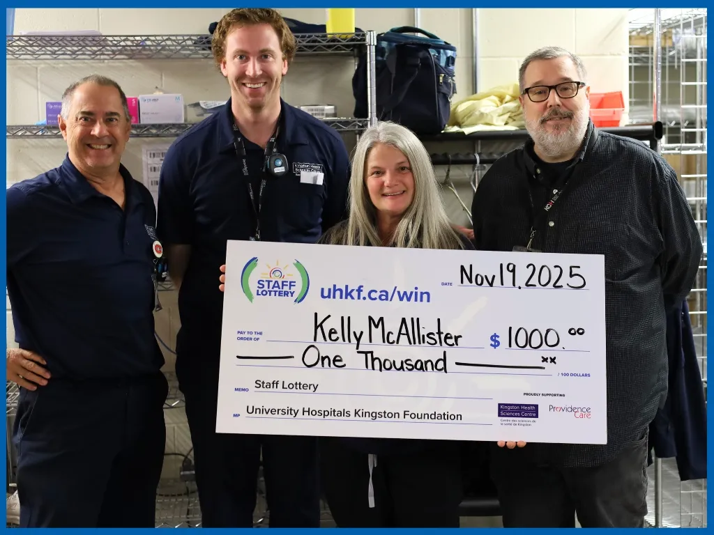 Kelly McAllister holding large cheque.