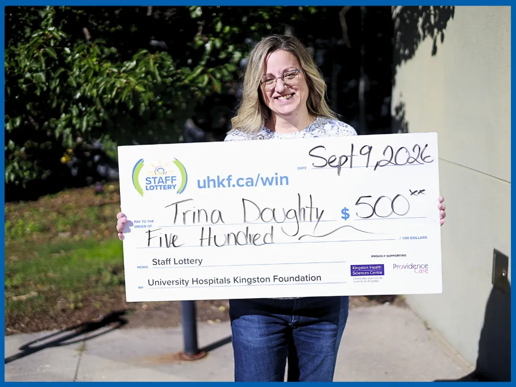 Trina Doughty holding a big Staff Lottery cheque
