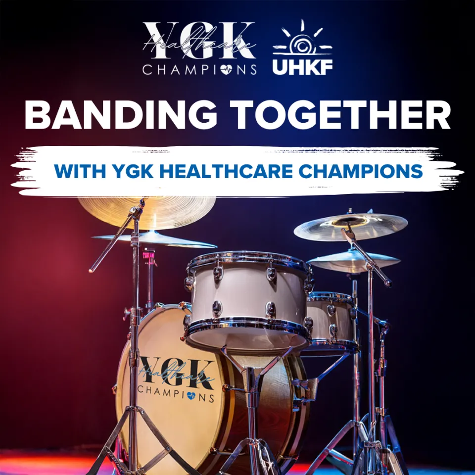 Poster for the upcoming Banding Together with YGK Healthcare Champions concert with an image of a drum set and mood lighting.