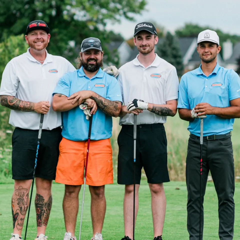 Mascon Restorations staff wearing blue and orange golf shirts and shorts at their 2nd annual golf tournament.