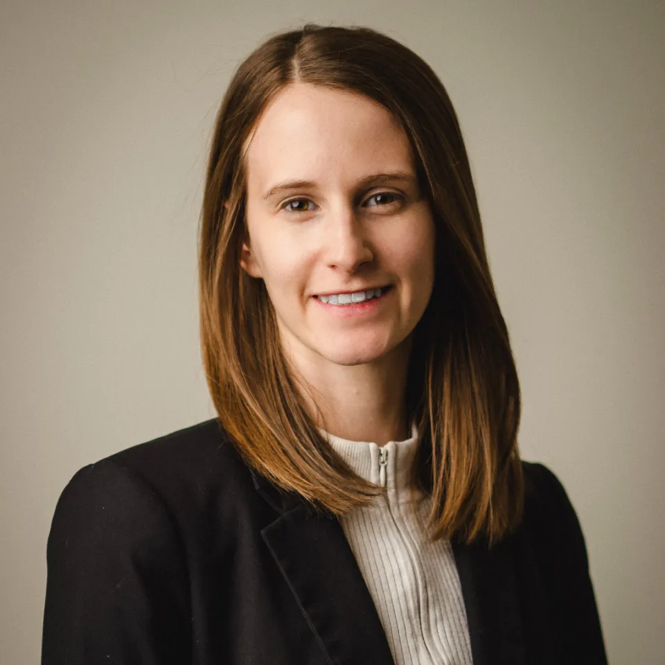 Megan Clarke smiling in a white shirt and black blazer.