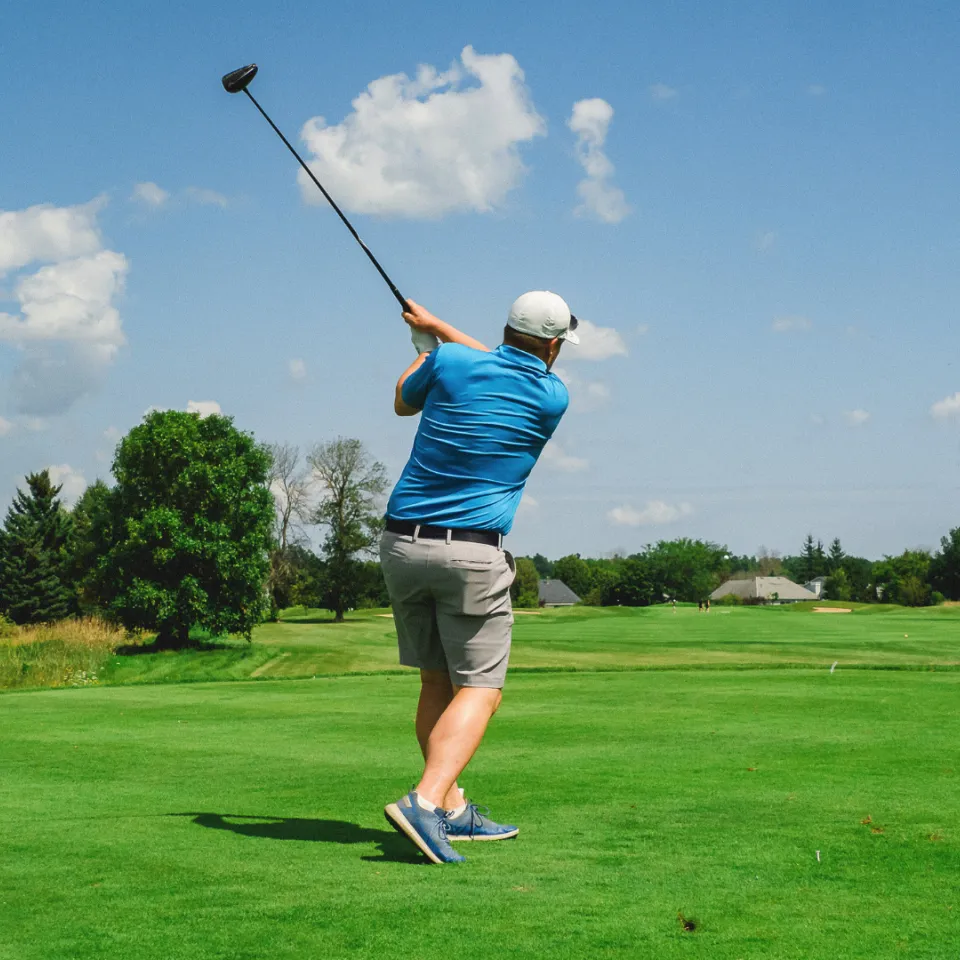 YGK Healthcare Champion swinging golf club on course.