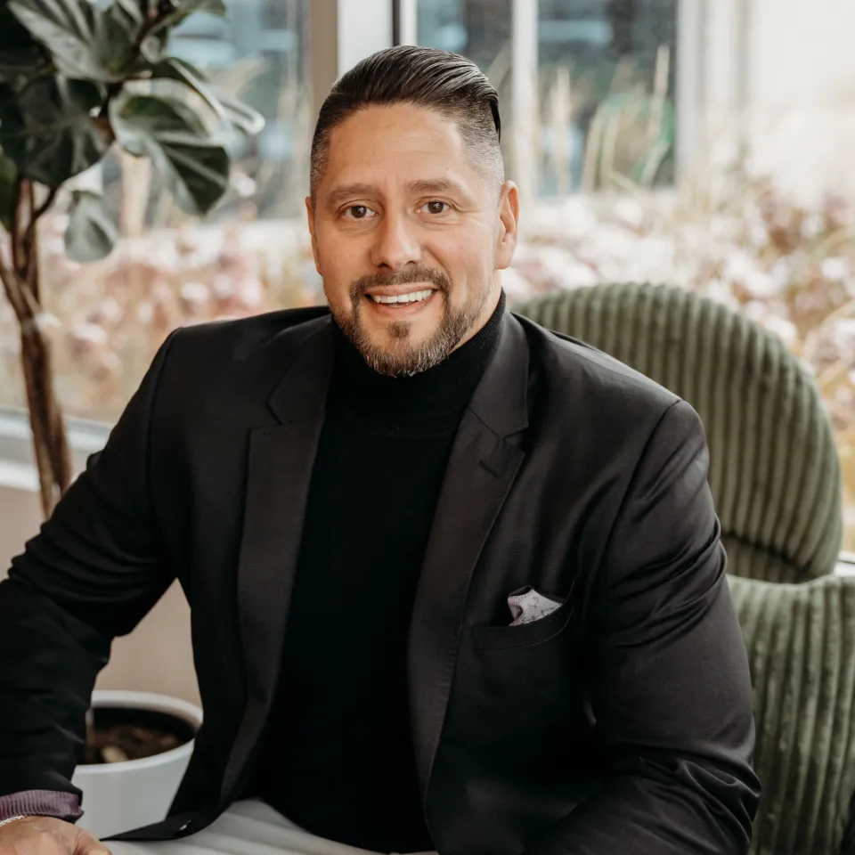 Brent Atkinson smiling while sitting down in a brightly lit room.